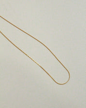 Gold chain on a light beige background