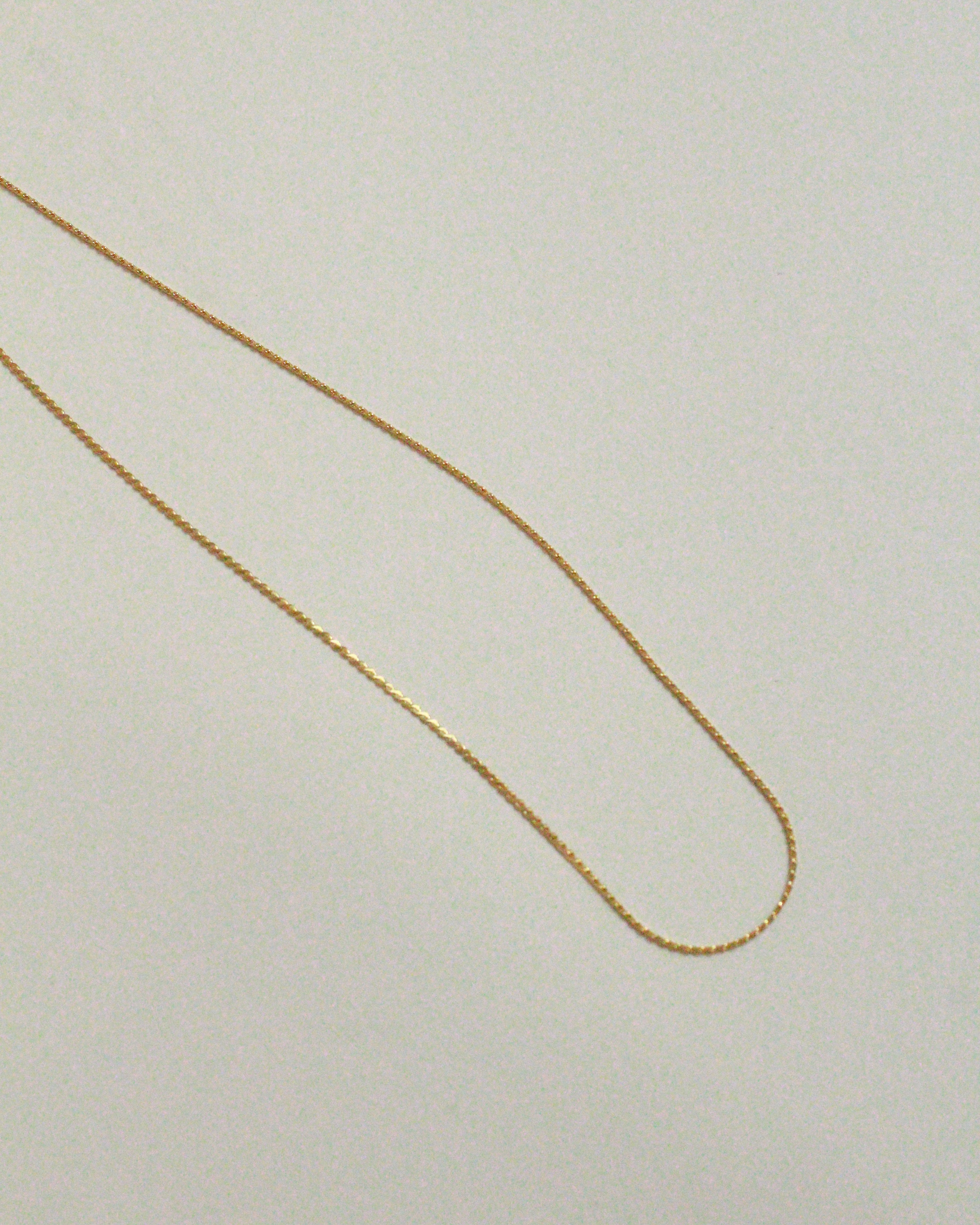 Gold chain on a light beige background
