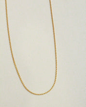 Gold chain on a light beige background