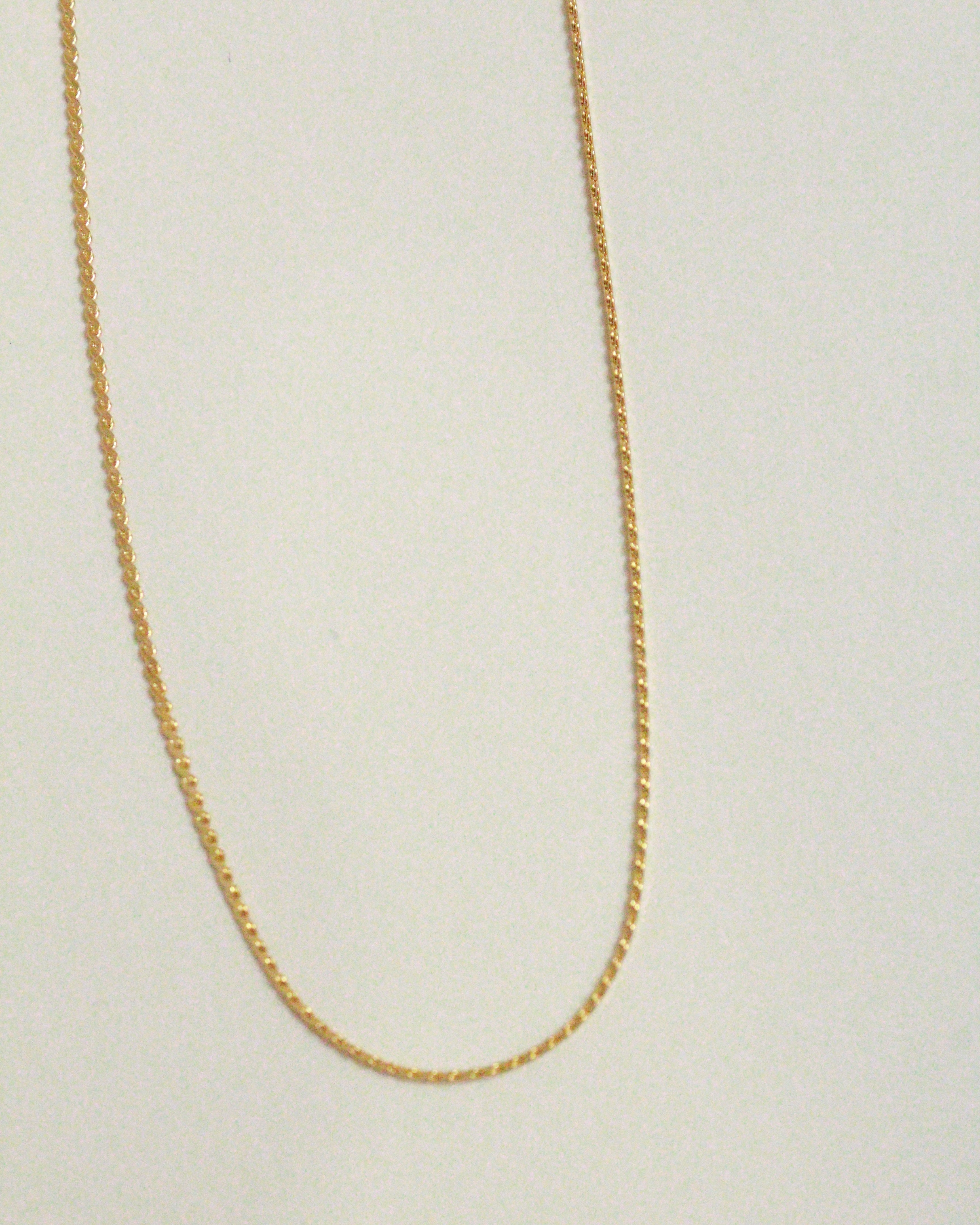 Gold chain on a light beige background