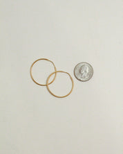 Two gold rings and a silver coin on a light gray background