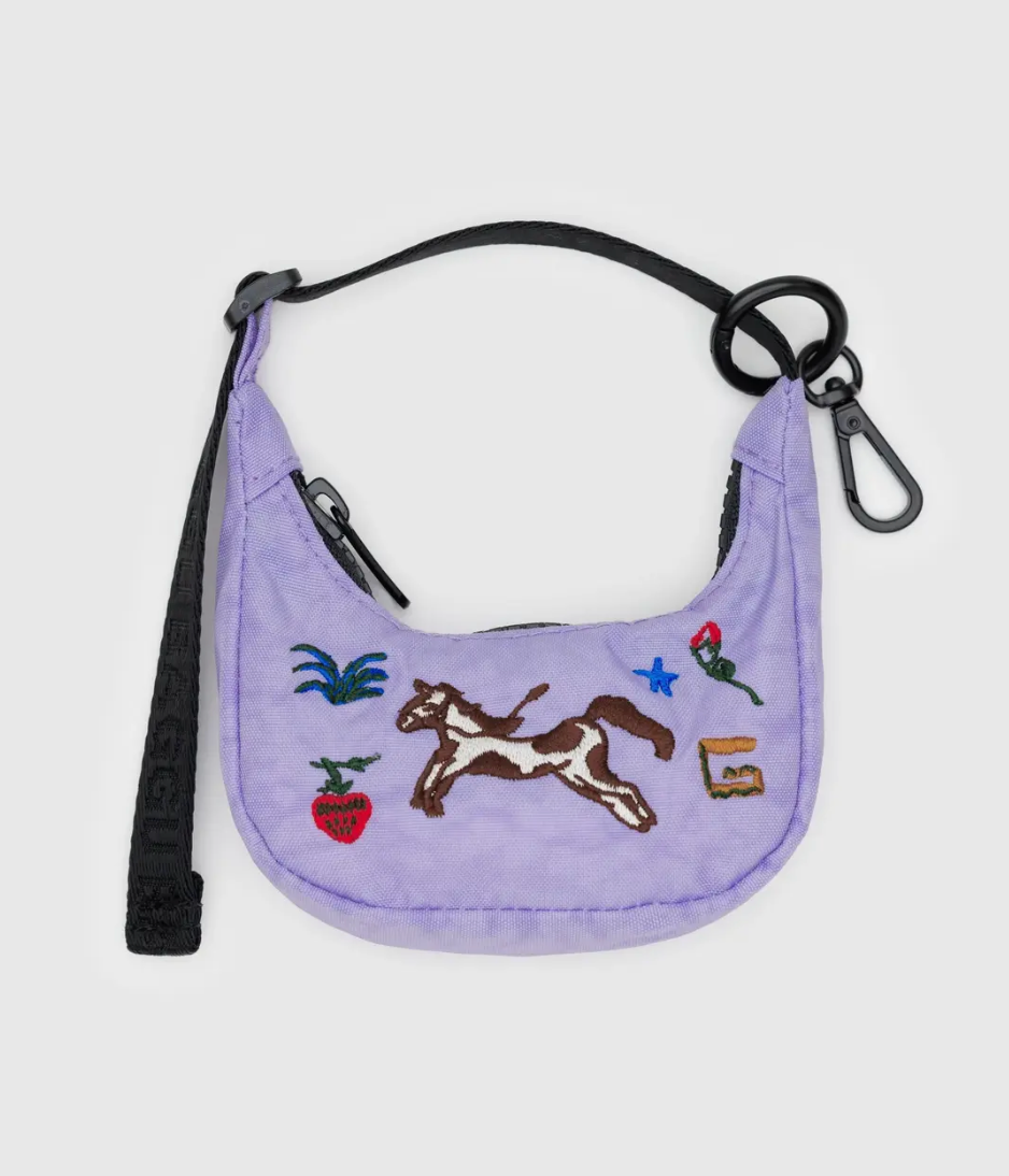 Purple bag charm in Crescent shape with horse design and black strap on a light gray background
