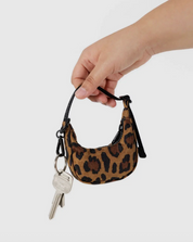 Leopard print keychain held by a hand on a white background