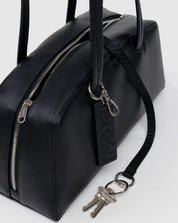 Black leather bag with a keychain on a white background