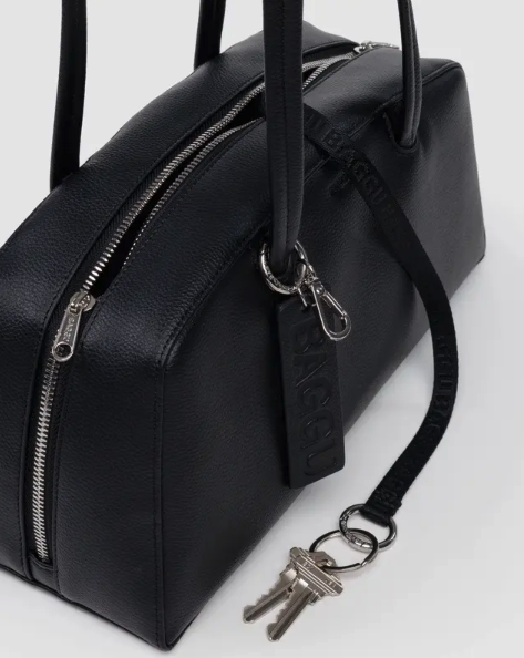 Black leather bag with a keychain on a white background