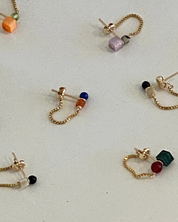 marida jewelry Gold chain earrings with colorful beads on a light gray surface