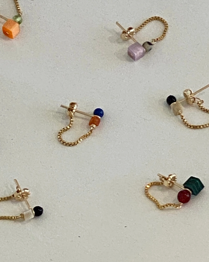 marida jewelry Gold chain earrings with colorful beads on a light gray surface