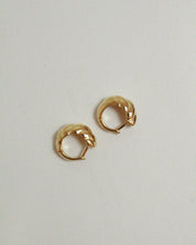 Pair of gold hoop earrings on a light gray background