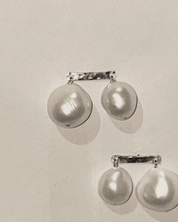 Pair of pearl earrings on a light gray background