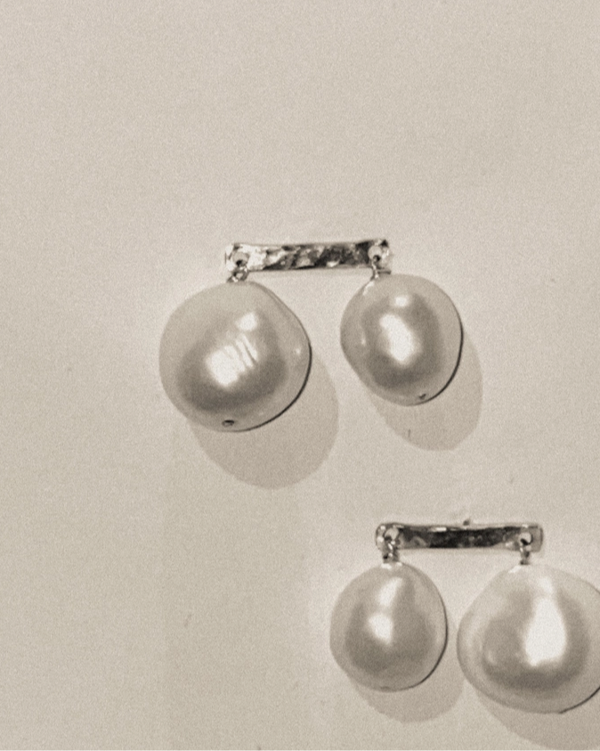 Pair of pearl earrings on a light gray background