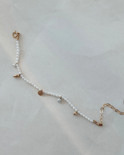 Pearl bracelet with gold accents on a light gray background