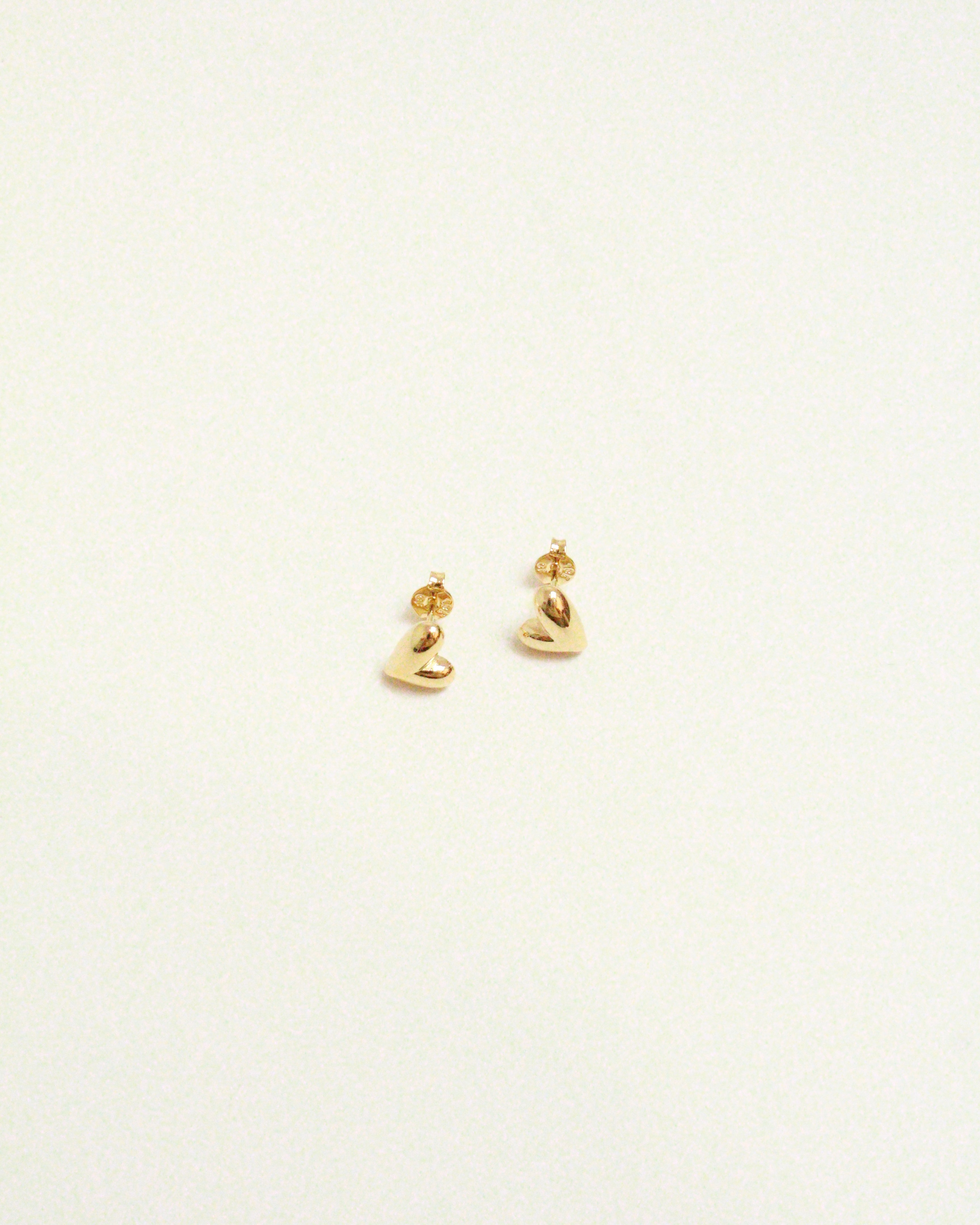 Pair of gold earrings on a light beige background