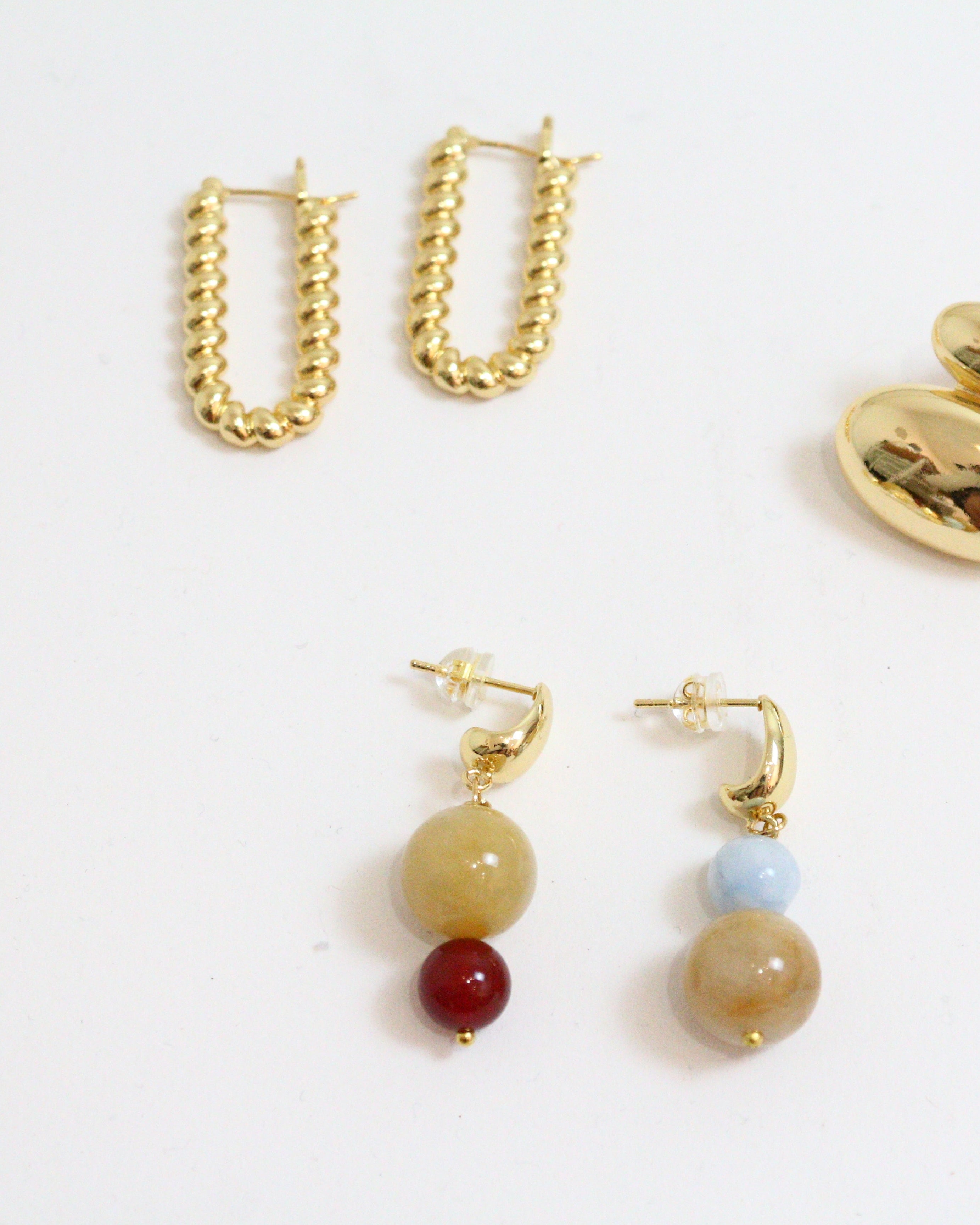 Set of gold earrings on a white background