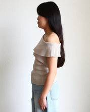 Woman wearing a beige Ribbed Off Shoulder Sleeveless Top and light blue jeans