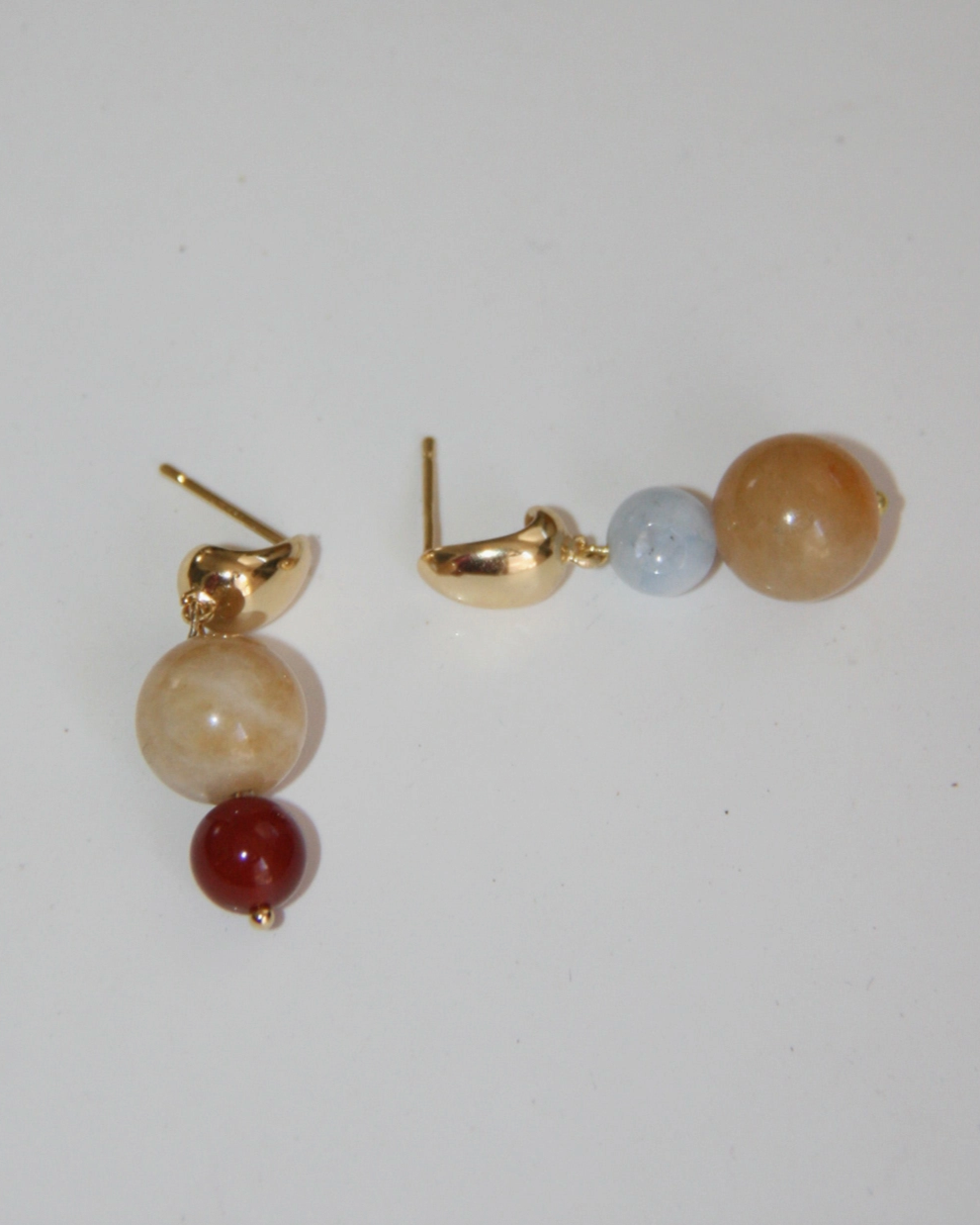Red light blue and topaz gemstones mismatched on gold earring
