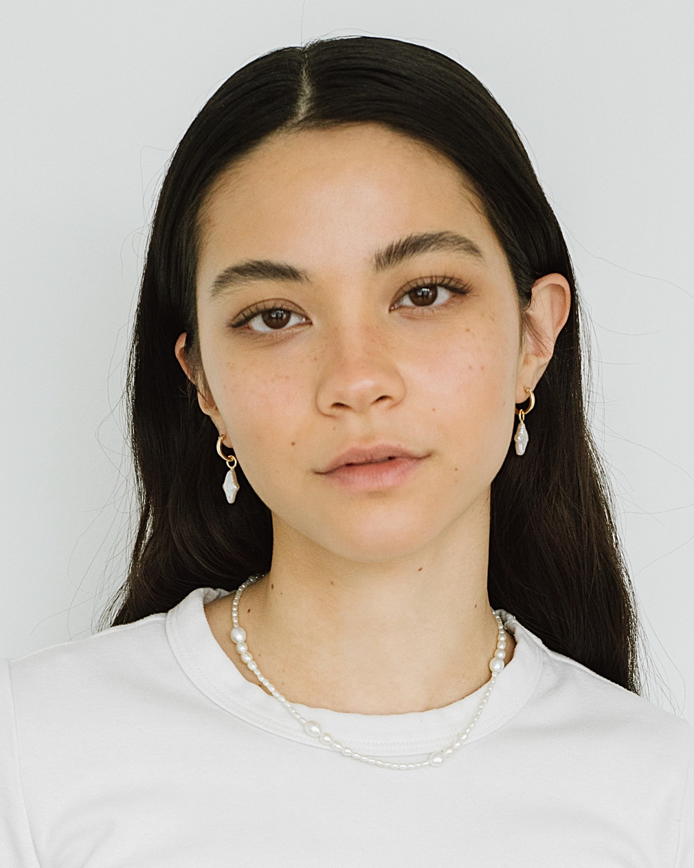 Woman wearing a white shirt against a plain background