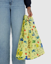 Person holding a yellow bag with colorful patterns on a white background