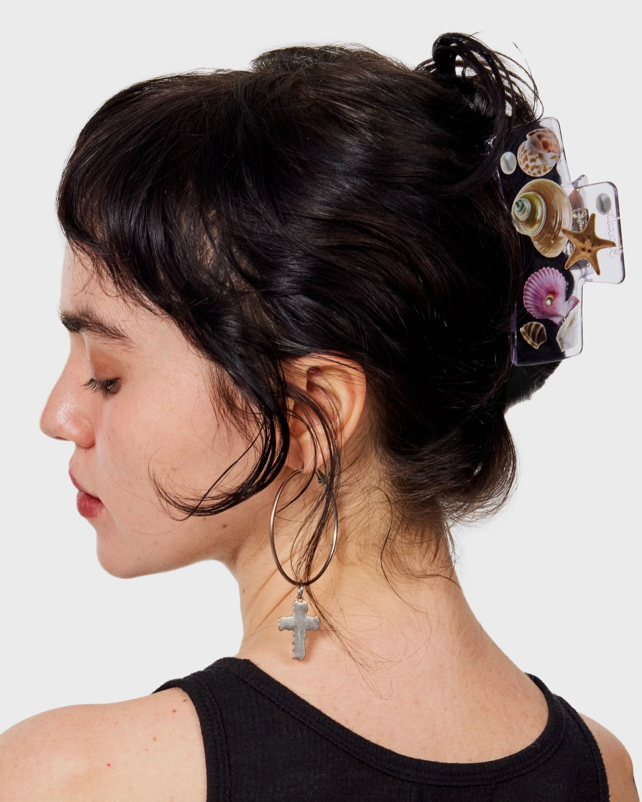 Woman with decorative hair clip on a plain background