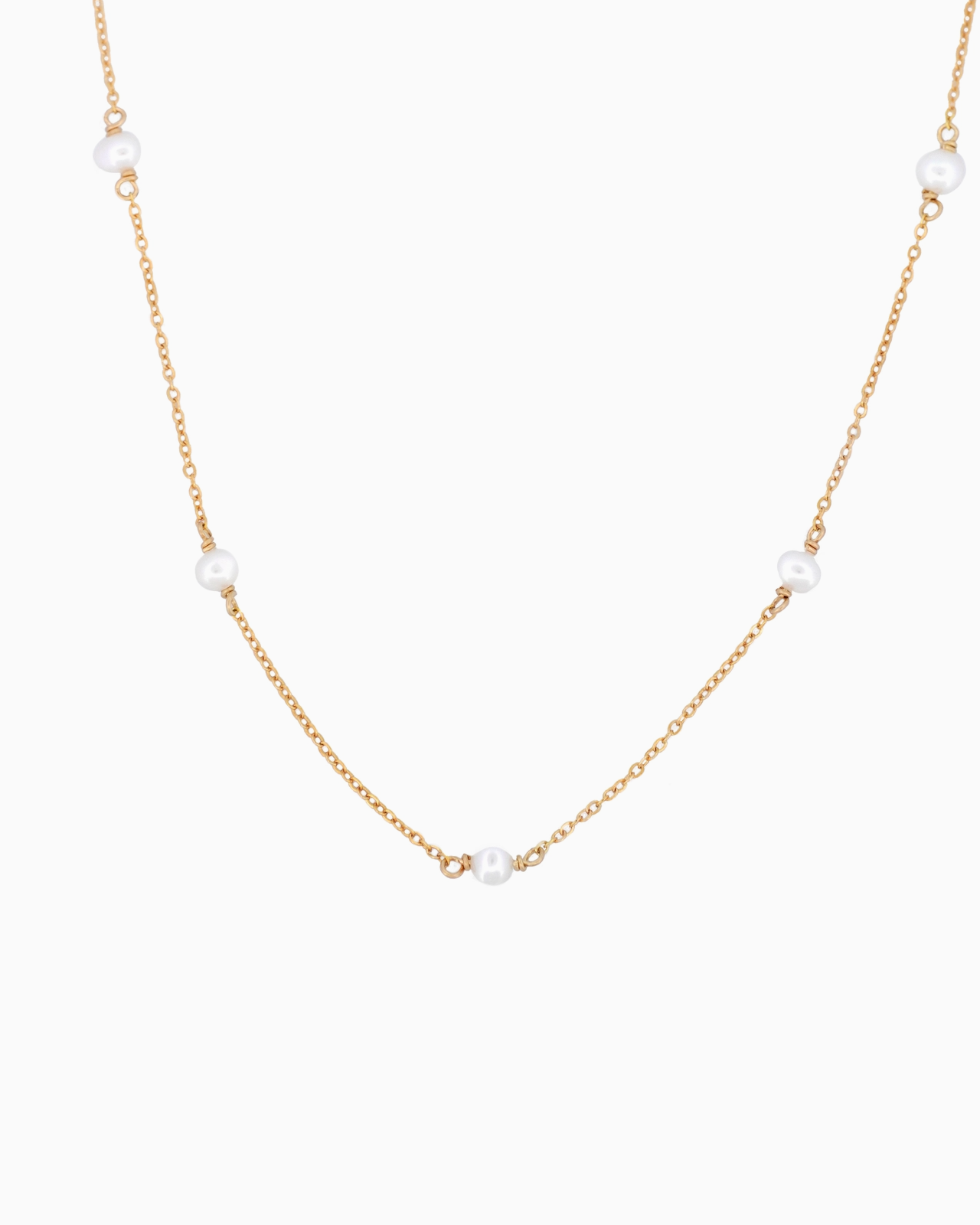 Gold necklace with pearls on a white background