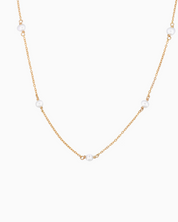 Gold necklace with pearls on a white background