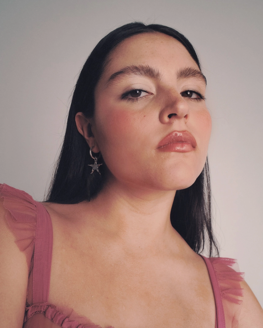 Woman wearing a pink dress against a plain background