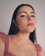 Woman wearing a pink dress against a plain background