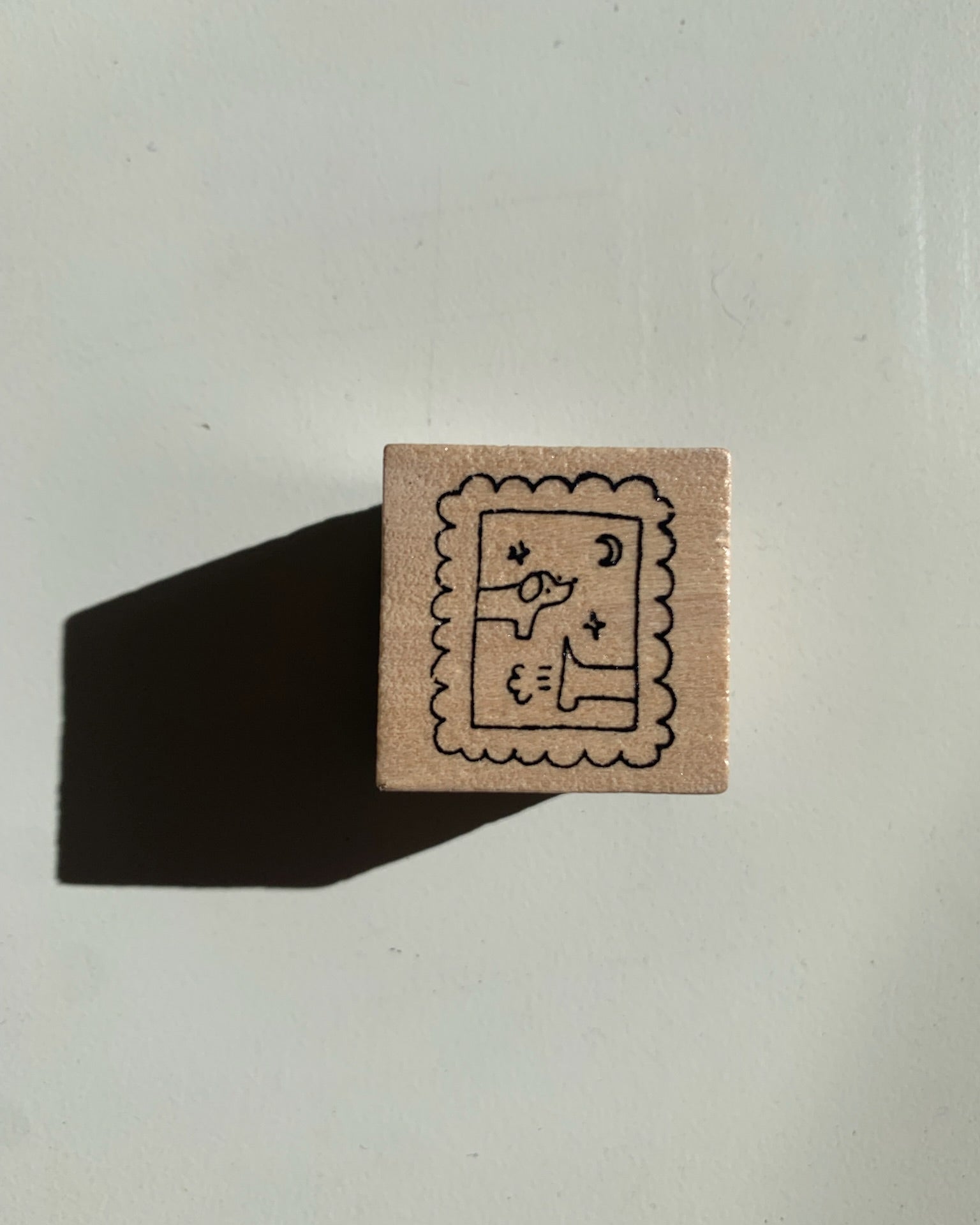 Square wooden stamp with a design on a white background