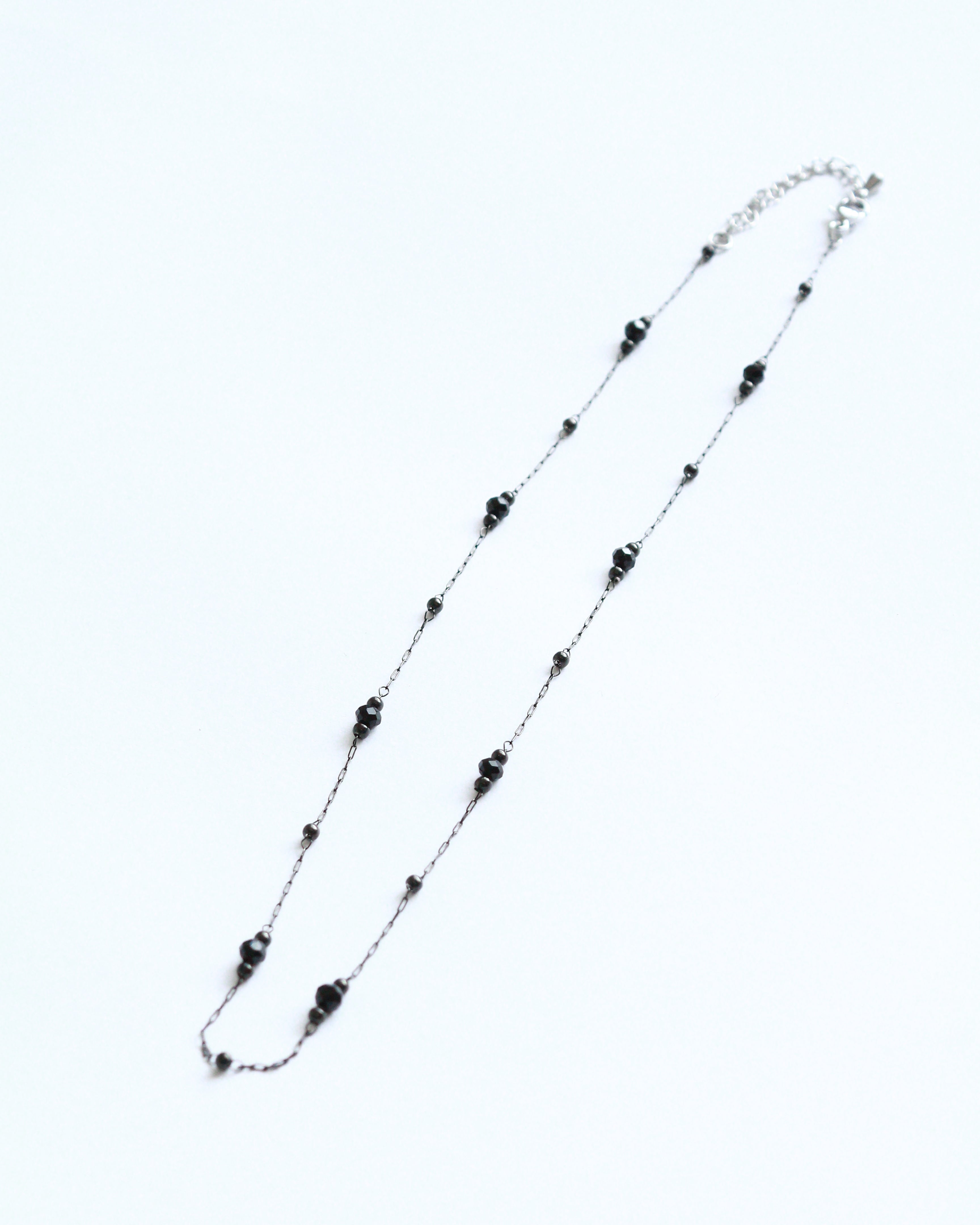 Necklace with black and clear beads on a white background