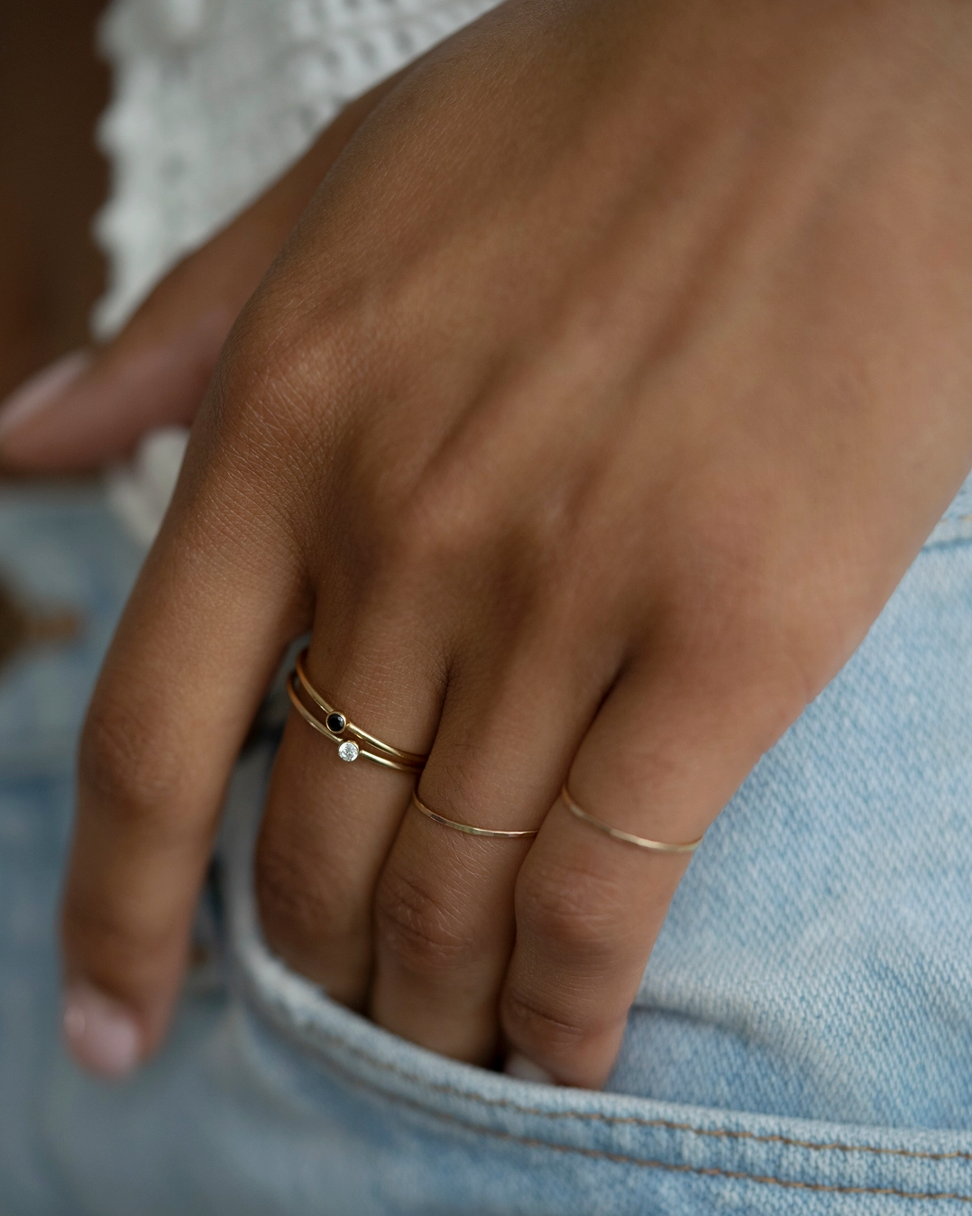 Close-up of a hand wearing gold rings with a blurred background