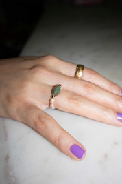 Hand with multiple rings on a marble surface