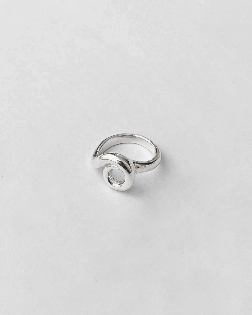 Silver ring with a custom loop in center on a light gray background