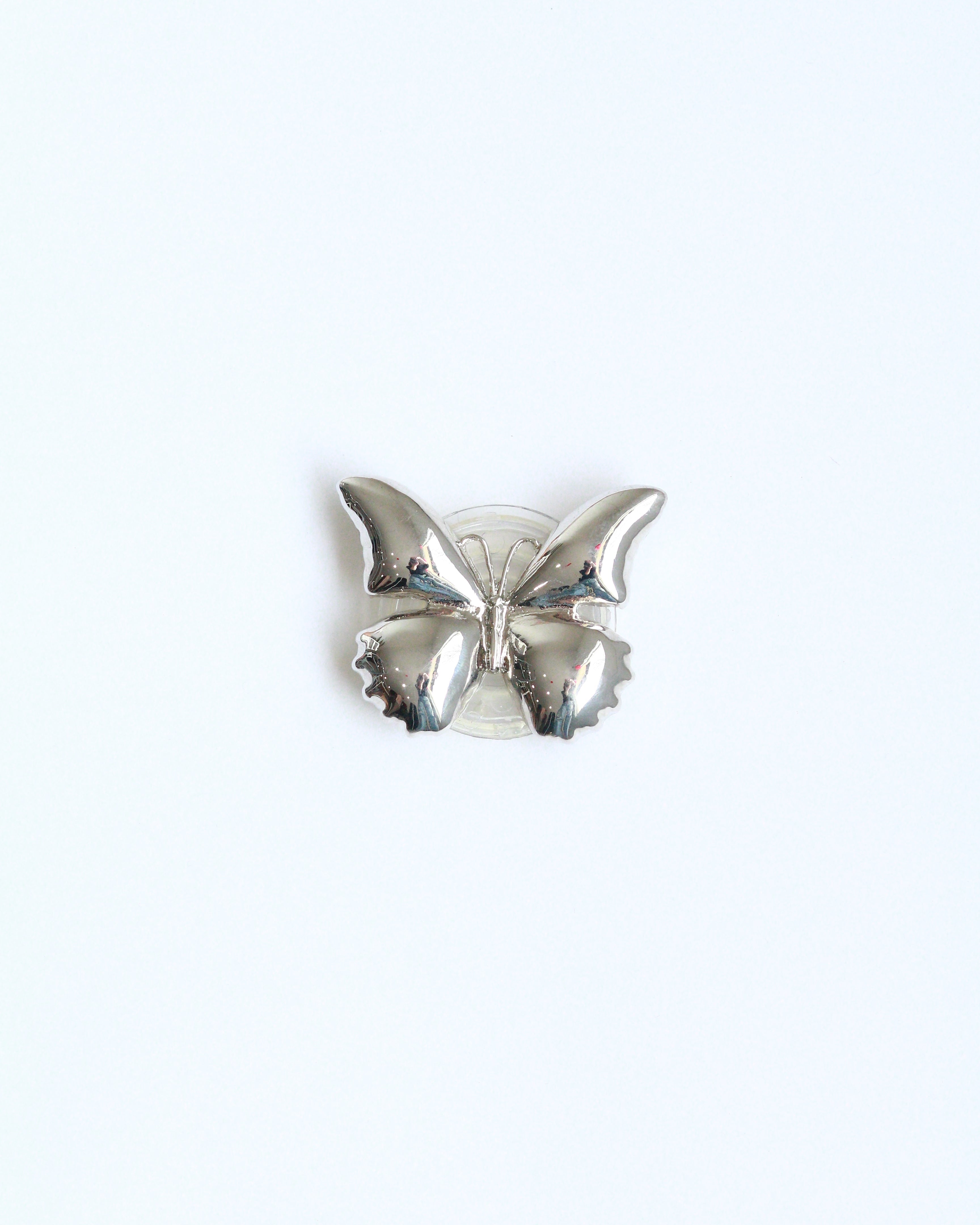 Silver butterfly-shaped brooch on a white background