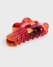 Red and gold hair clip on a white background