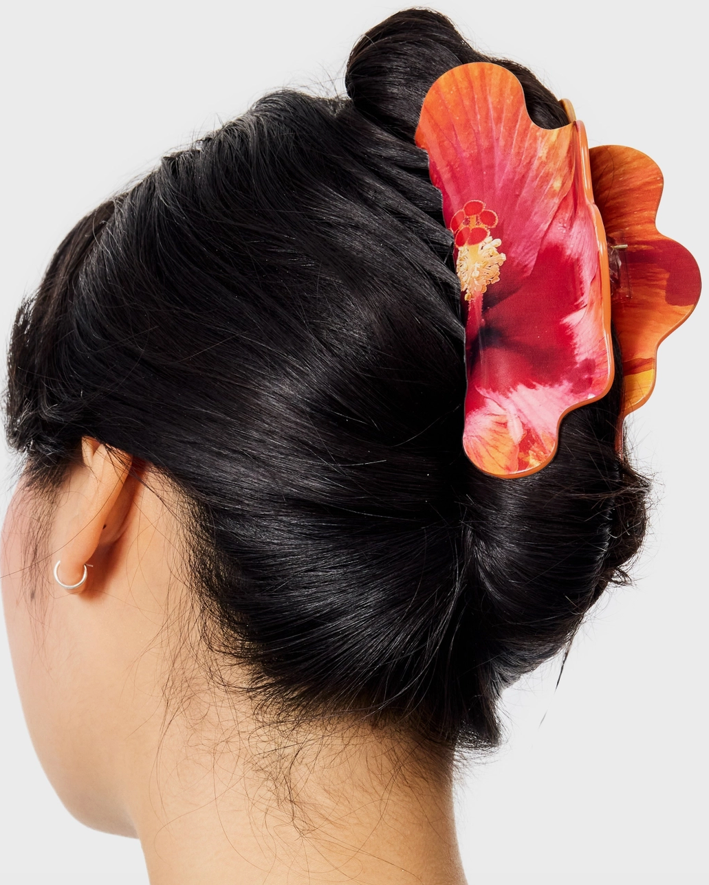 Person with a floral hair clip in their hair on a white background