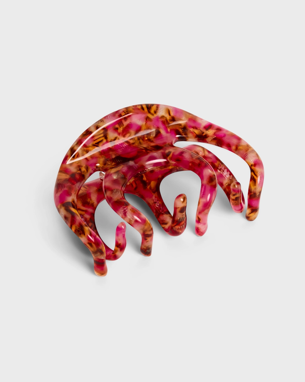 Pink and brown tortoiseshell hair claw clip on a light gray background