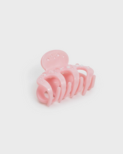 Pink hair clip on a light gray background