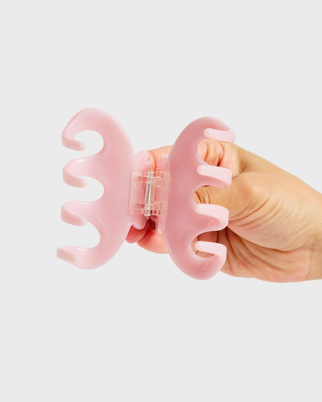 Hand holding a pink tool with a white background