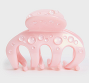 Pink hair clip with bubble design on a light pink background