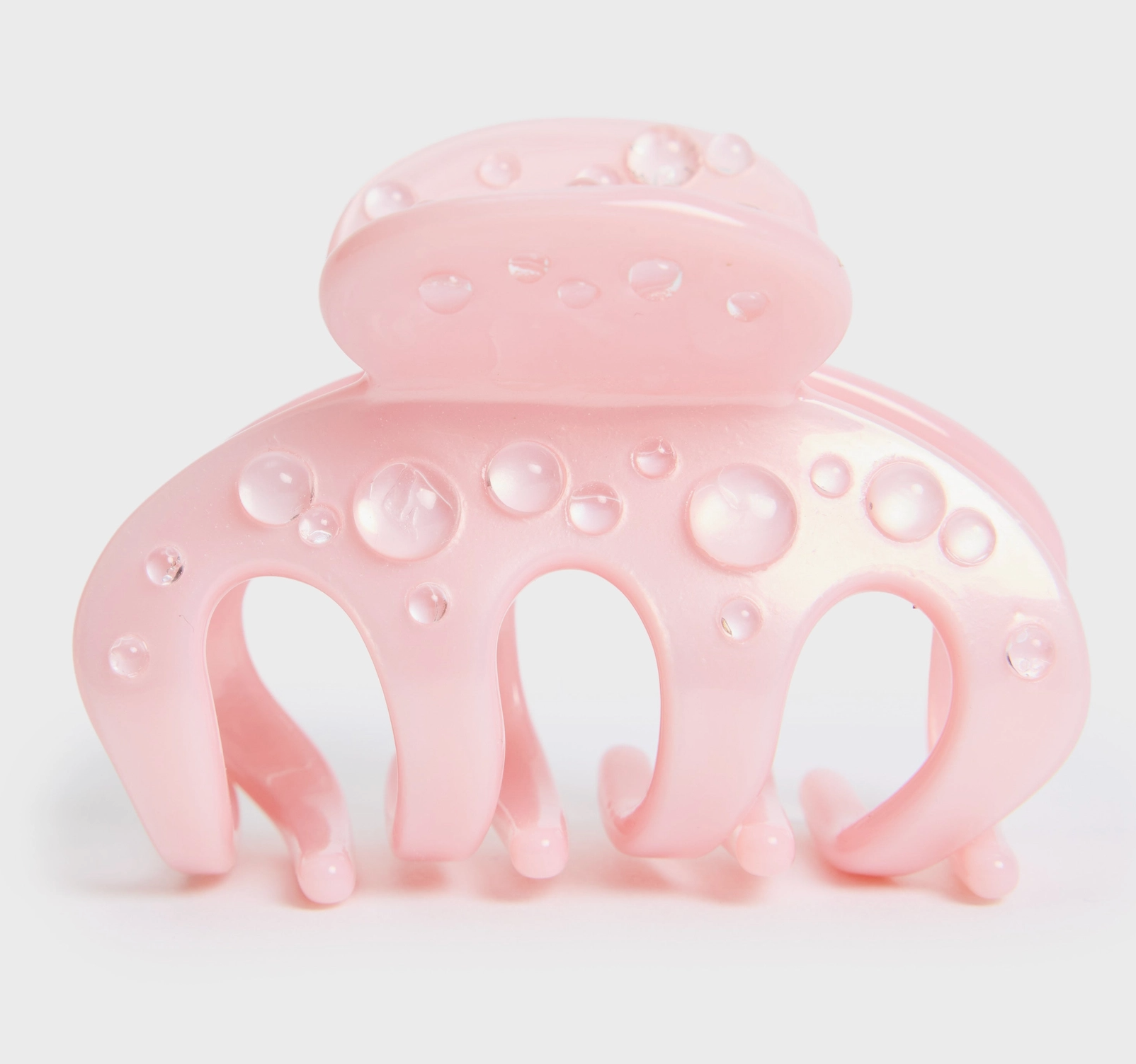 Pink hair clip with bubble design on a light pink background