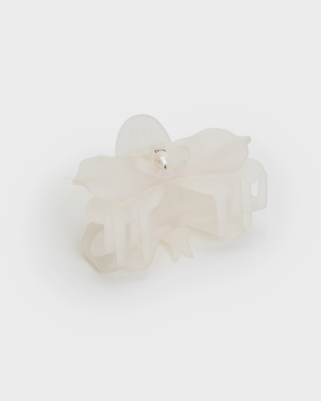 white frosted orchid shape hair claw clip by Chunks. pearl charm attached to clip. 