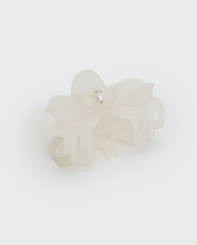 white frosted orchid shape hair claw clip by Chunks. pearl charm attached to clip. 