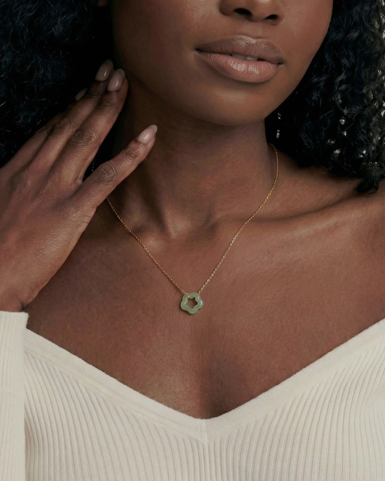 Woman wearing a gold necklace with a hexagonal pendant