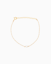 Gold bracelet with a pearl on a white background