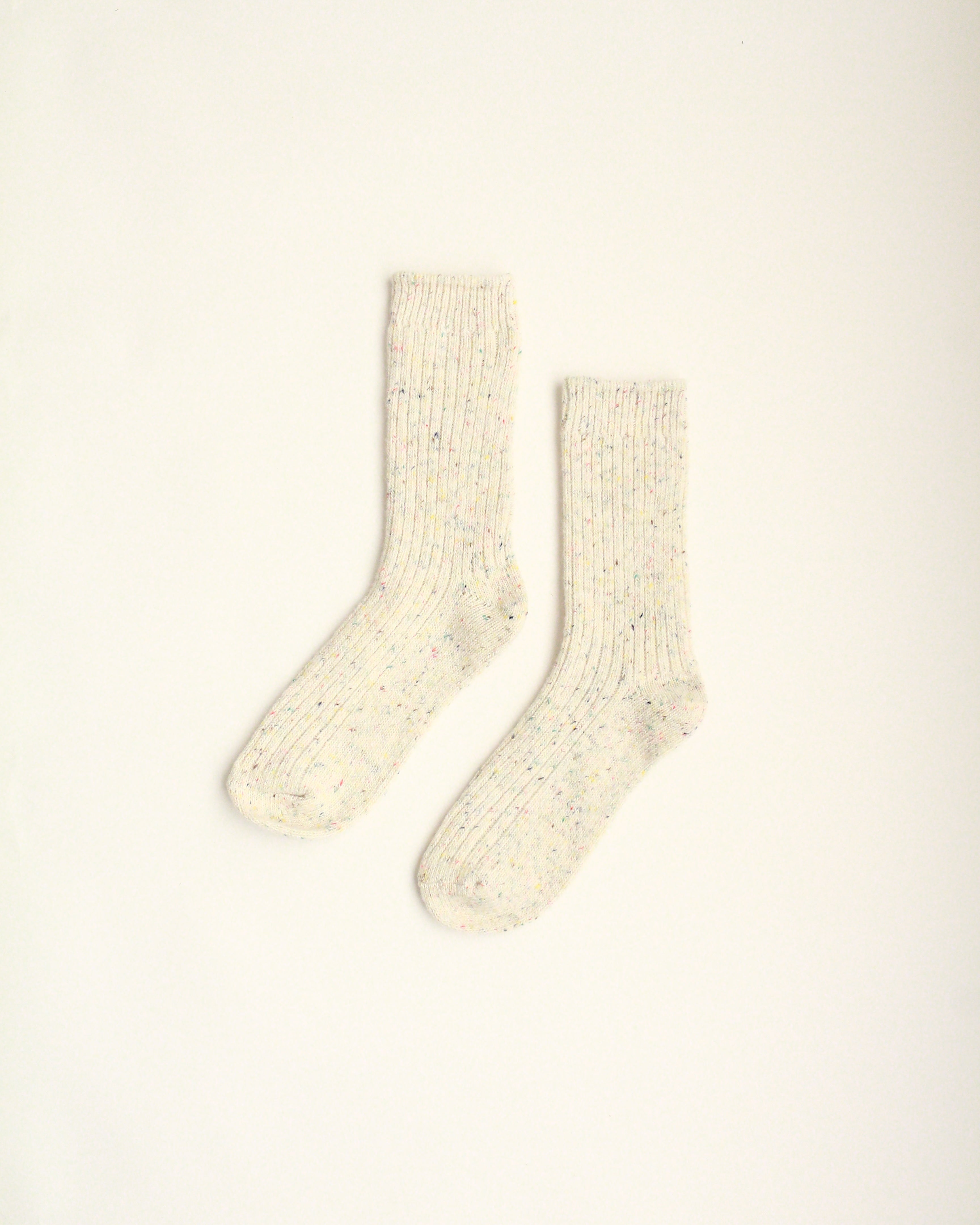 Pair of beige socks on a light beige background
