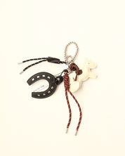 Keychain with horseshoe, horse figure, and braided cord on a white background