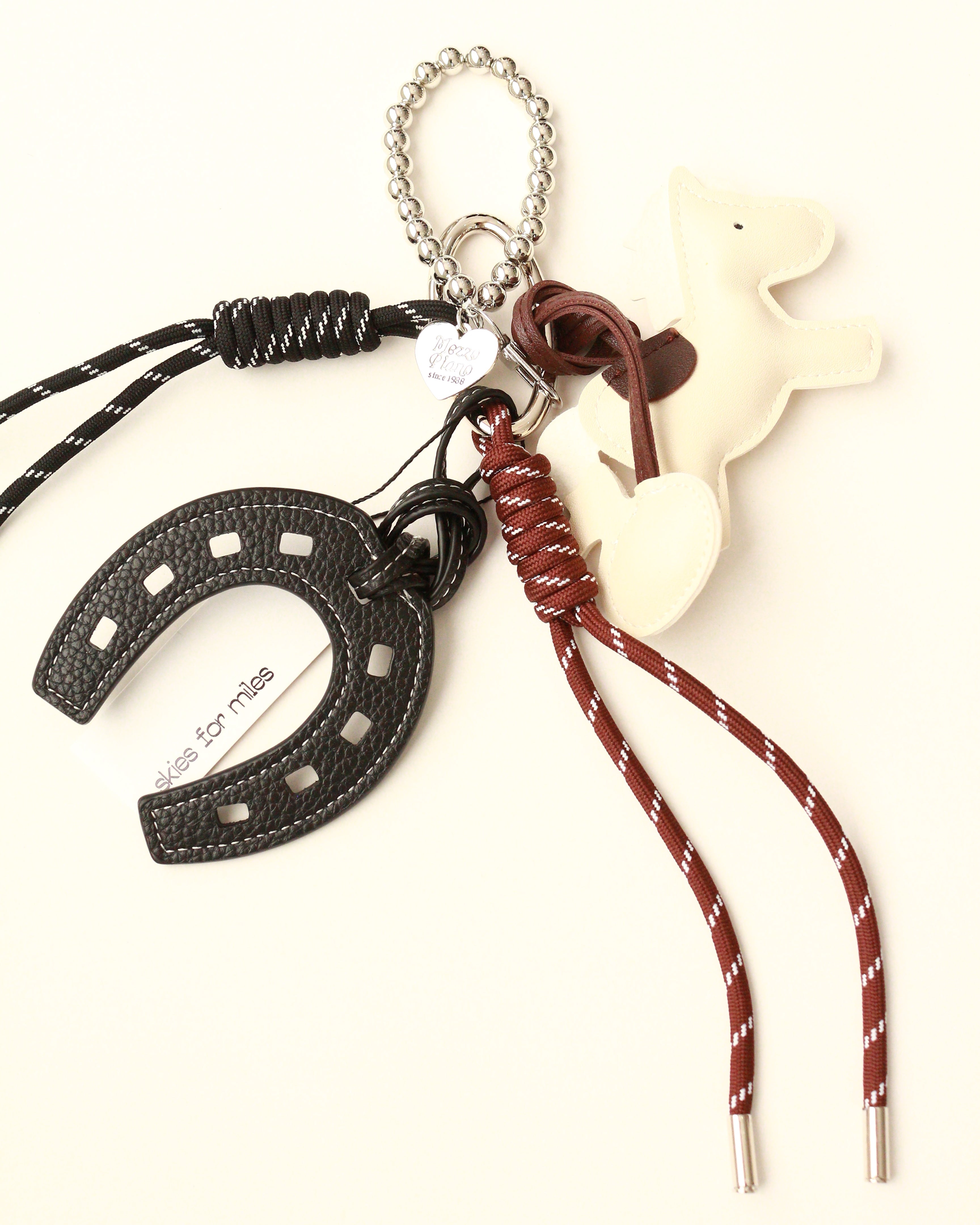 Necklace with horse shoe, horse figure, and keychain on a white background