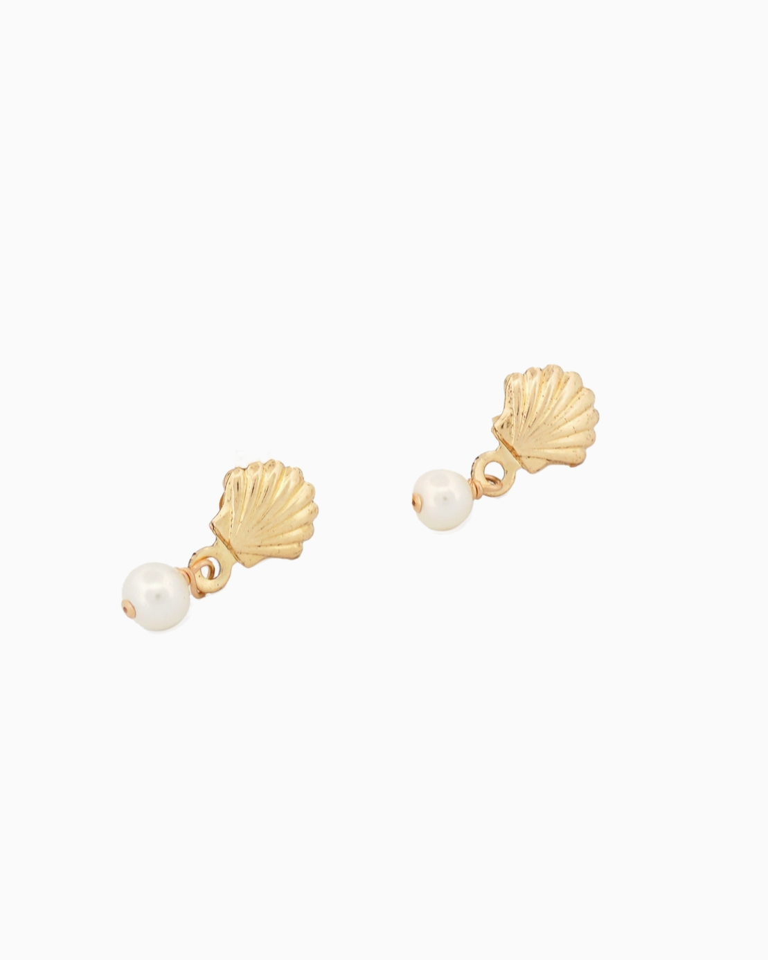 Gold shell and pearl earrings on a white background
