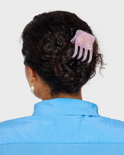 Person wearing a decorative hair comb in their bun against a plain background