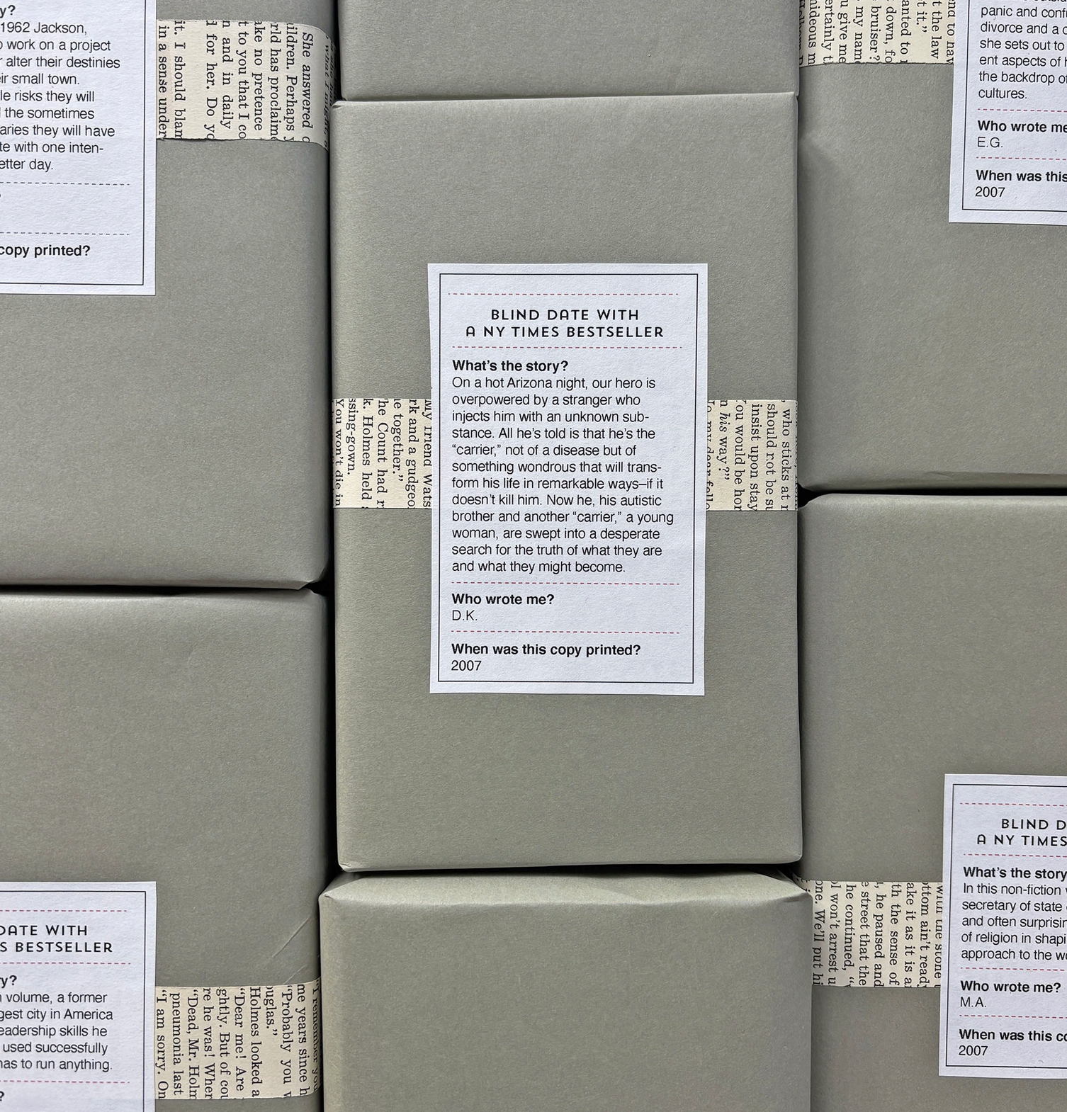 Several books wrapped in gray paper with printed book labels, stacked tightly together.