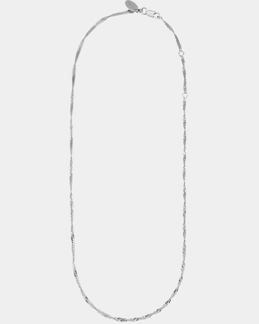 Silver necklace on a light gray background